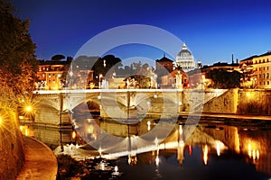 Rome, Italy - view of a bridge over Tiber river and St. Peter's Basilica dome in Vatican at night
