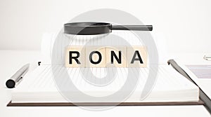 rona word concept. wooden cubes, notepad, pen and business charts photo