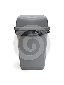 Ront view of trash can with bag isolated on white background. Close up of gray plastic trash can. Black plastic bag in gray