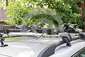 Roof bike rack on a silver car, coutryside landscape in background