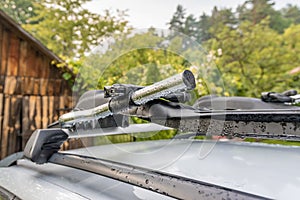 Roof bike rack on a silver car, coutryside landscape in background