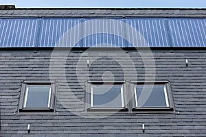 Roof of black slate tiles, roof Windows and fixed solar panels