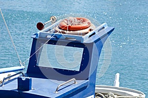 Roof of a blue boat with orange lifebuoys