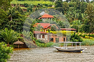 Roof boat anchored at the coast with rwandan village in the background, Kivu lake, Rwanda