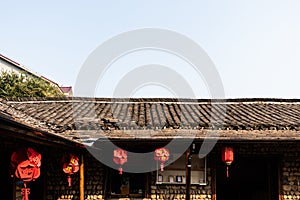 The roof of the building is covered with old roof tiles. Asia, the Chinese lanterns are red.