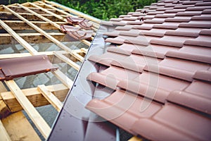 Roof building at new house construction. Brown roof tiles covering estate