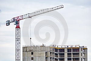 Roof of building under construction and tower crane transporting materials