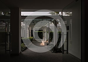 The roof and ceiling of the structure is glass and steel. Perspctive view of The stone floor and white concrete pillars leading to