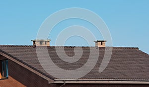 Roof with chimneys under clear blue sky