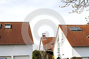 Roof of classic residential houses with orange roofing tiles and