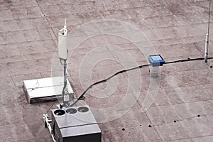 Roof of a commercial building with a external units of the commercial air conditioning and ventilation systems, cellular antenna a
