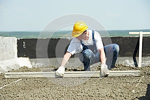 Roof construction. worker roofer leveling with float lute