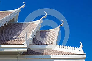 roof with decoration of the Buddhist white temple Wat Sawang Arom against the sky photo