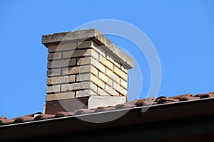 Roof detail of a detached house with red roof tile and beige chi