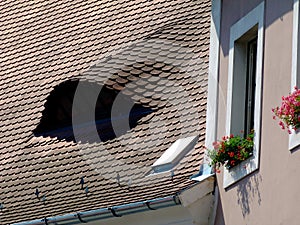 Roof dormer of arched shape with beavertail shape clay roof tiles.