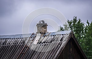 Roof and facade with a window of an old wooden country house