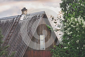 Roof and facade with a window of an old wooden country house