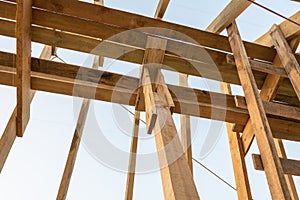 Roof frame structure in wood frame home under construction at sunset