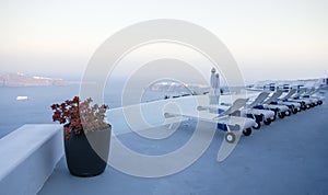 Roof garden of a holiday resort hotel against the ocean at sunset. Oia village, Santorini Island, Greece.