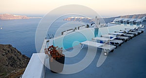 Roof garden of a holiday resort hotel against the ocean at sunset. Oia village, Santorini Island, Greece.