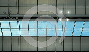 Roof and glass skylights of the airport. Interior architecture design. Skylights with lamp light. Modern building roof structure.