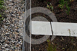 Roof gutter covered with a square plastic green grid. green roofs covered with substrate. the area around the drain is mulched wit