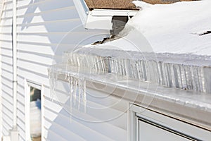 Roof gutter full of ice and icicles after winter storm