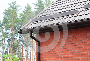 Roof gutter with metal snow board for snow protection. Metal roofing construction with guttering