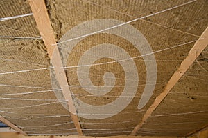 Roof heat isolation with mineral wool in wooden house, building under construction