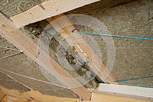 Roof heat isolation with mineral wool in wooden house, building under construction