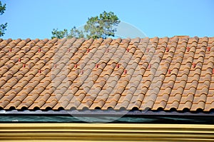 Roof house with tiled roof on blue sky. detail of the tiles and corner mounting on a roof, horizontal. roof protection from snow