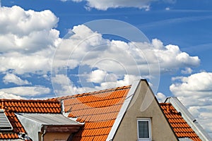 Roof of house with windows and yellow roof tiles