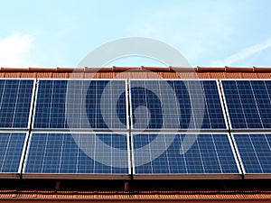 Roof installed photovoltaic solar panels on sloped clay roof