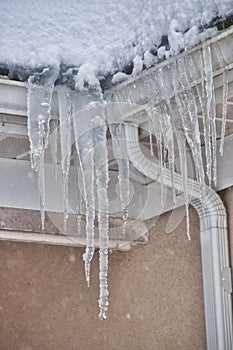 Roof line with long icicles taken while it is still snowing