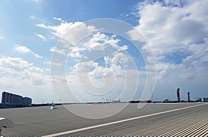 Roof of metal sheet building with clear blue sky.