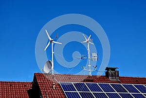 roof with multiple sources of alternative energy. wind turbine propellers.