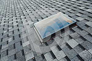 Roof of new house with shingles roof-tiles and ventilation window