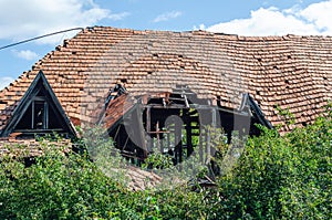 Roof of an old abandoned house with broken and fallen tiles