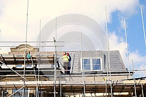 Roof operative working off scaffolding , roof repairs. photo