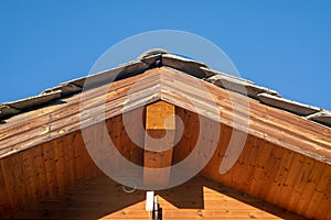 roof, particular truss with exposed wooden beams. interlocking beam structure covered with wooden beading. thermal coat, energy