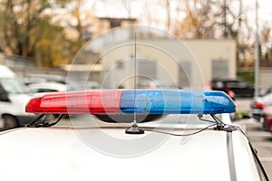 Roof of a police patrol car with flashing blue and red lights, sirens and antennas