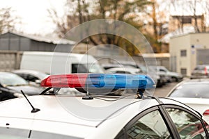 Roof of a police patrol car with flashing blue and red lights, sirens and antennas