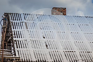 Roof of a private house in the snow. Tiled roof in the snow. Winter time. The roof is covered in snow. Part of roof clear from