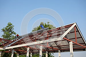 Roof repair, Construction worker installing new roof, roofing tools, power drill used on new roof with sheet metal. Roofing -