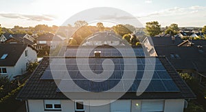 Roof of a residential building covered in solar panels, capturing sunlight. The panels