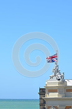 Roof Statues on Oamaru Stone Building with New Zealand flag at Oamaru.
