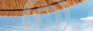 The roof of a straw umbrella against the background of blue water