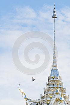 The roof of a Thai temple is decorated with silver glass