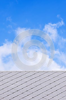 Roof tiles against clouds in the blue sky