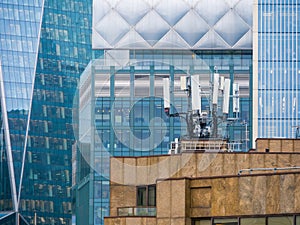 A roof top city view of mobile telecommunications masts and aerials.